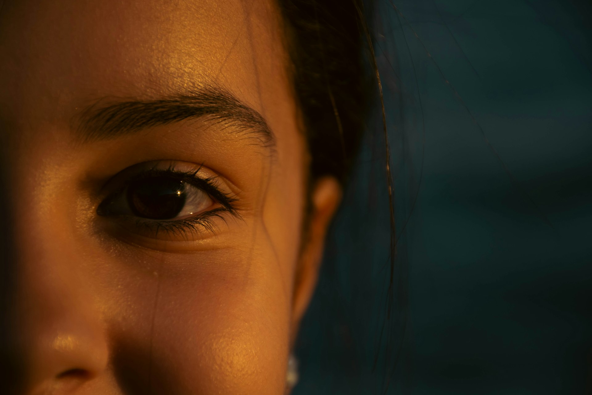 A close up of a woman's face with a ring on her finger